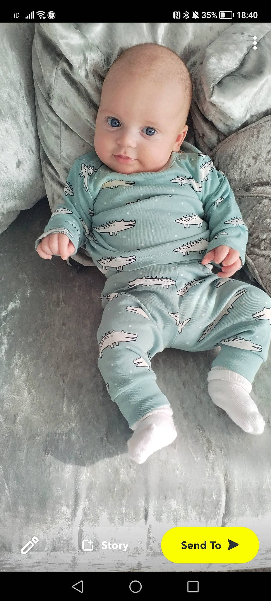 Jesse is registered to the contest to win money with this photo: baby, baby_toddler_clothing, barefoot, cheek, child, comfort, foot, human_leg, linens, pattern, person, portrait_photography, sitting, skin, sleeve, smile, toddler