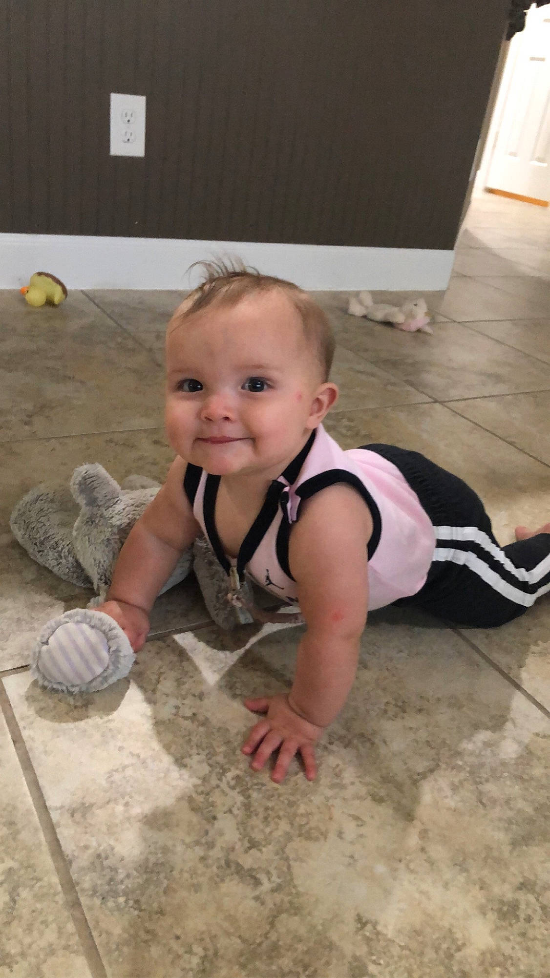 Danika is registered to the contest to win money with this photo: baby_toddler_clothing, ball, child, floor, flooring, foot, fun, grass, happy, hardwood, home_appliance, human_leg, joy, leisure, person, recreation, sitting, smile, soil, t_shirt