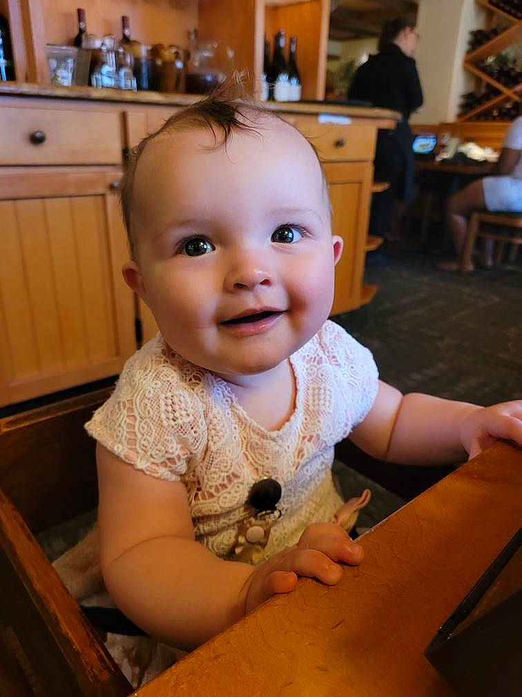 Danika is registered to the contest to win money with this photo: baby, baby_toddler_clothing, cabinetry, chair, cheek, child, drawer, floor, flooring, fun, hardwood, head, iris, joy, kitchen_appliance, person, skin, smile, standing, table