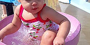 Remi is registered to the contest to win money with this photo: child, colorful, concrete, daytime, fun, outdoor, person, pink_basin, plastic, playground, slide, splashing, summer, sunlight, swimsuit, toddler, train, water, water_play, wet_hair