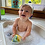 Kota is registered to the contest to win money with this photo: baby, bath, bubbles, child, clean, cute, dinosaur_cup, face, foam, happy, indoor, kitchen, person, playful, sink, skin, smiling, toy, water, window