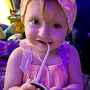 Octavia joined the competition — help win amazing prizes! toddler, child, baby, headband, bow, pink_dress, toy, indoor, smiling, hands, face, curly_hair, playing, purple_light, furniture, bedroom, cute, young_child, portrait, closeup