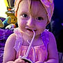 toddler, child, baby, headband, bow, pink_dress, toy, indoor, smiling, hands, face, curly_hair, playing, purple_light, furniture, bedroom, cute, young_child, portrait, closeup