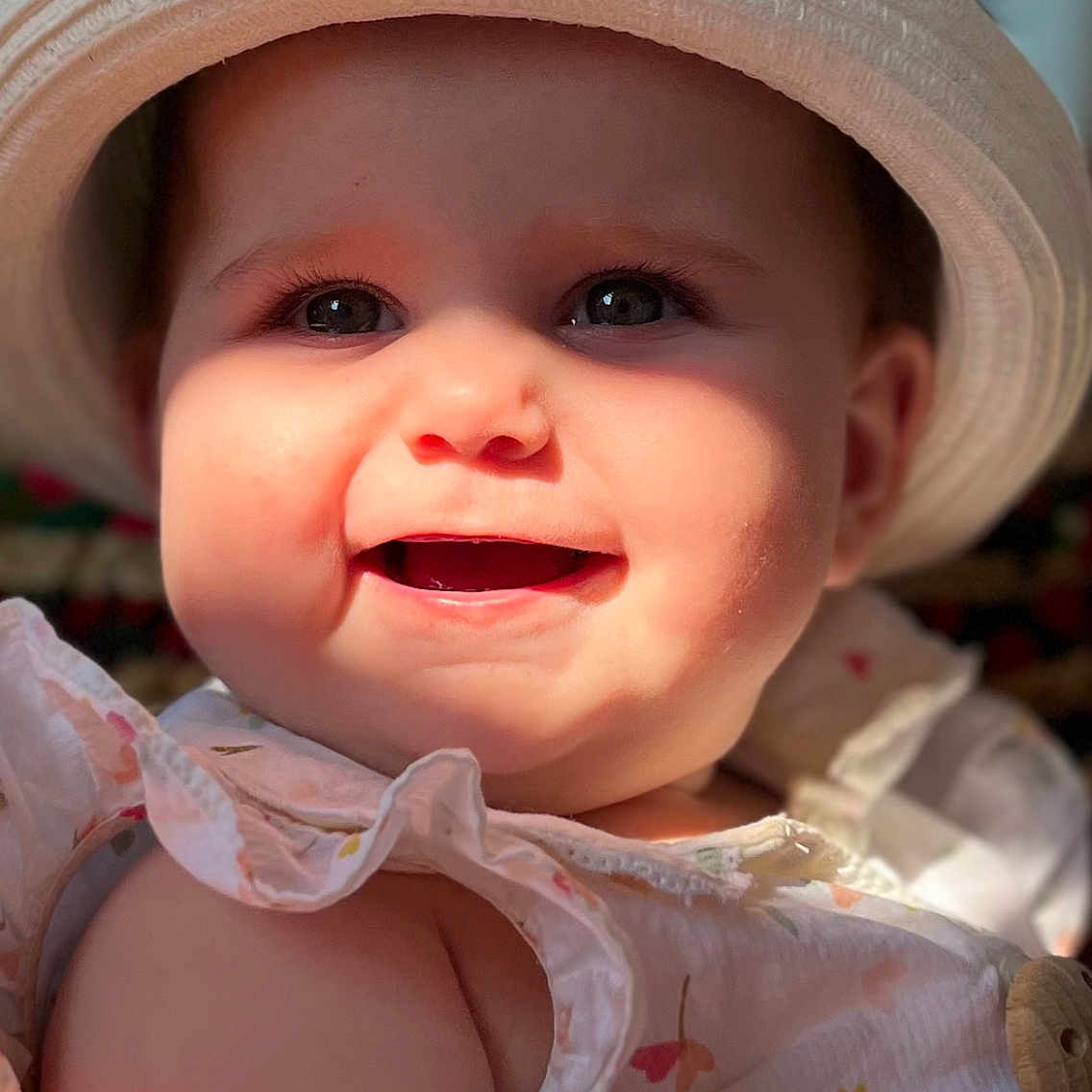 Ava participe au concours pour gagner de l'argent avec cette photo : baby, babywear, cheeks, child, closeup, clothing, cute, face, floral, happy, hat, infant, innocence, outdoor, person, portrait, shadow, skin, smiling, sunlight