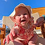 Grace is registered to the contest to win money with this photo: baby, child, smiling, hat, sunhat, outdoor, blue_sky, chair, hand, person, happy, infant, clothing, skin, daylight, wood, seat, cute, reaching, portrait