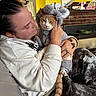 Malcom joined the competition — help win amazing prizes! cat, orange_cat, white_cat, pet, animal, costume, elephant_costume, human, person, cuddling, indoors, living_room, couch, fireplace, portrait, gray_fabric, whiskers, tail, serious_expression, cozy