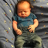Isaiah is registered to the contest to win money with this photo: baby, sleeping, infant, blue_clothing, denim_jeans, bed, blanket, pattern, curly_hair, hands, feet, cute, peaceful, child, portrait, indoors, young, soft_lighting, rest, casual_wear