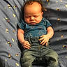 baby, sleeping, infant, blue_clothing, denim_jeans, bed, blanket, pattern, curly_hair, hands, feet, cute, peaceful, child, portrait, indoors, young, soft_lighting, rest, casual_wear