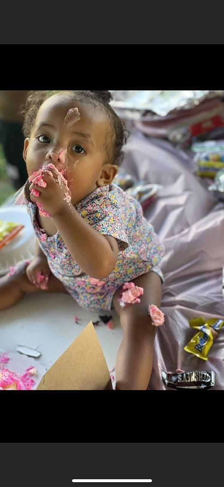 Zoey is registered to the contest to win money with this photo: baby, baby_toddler_clothing, cheek, child, event, face, finger, food, fun, happy, leisure, mouth, person, pink, shorts, sitting, skin, table, tableware, thigh