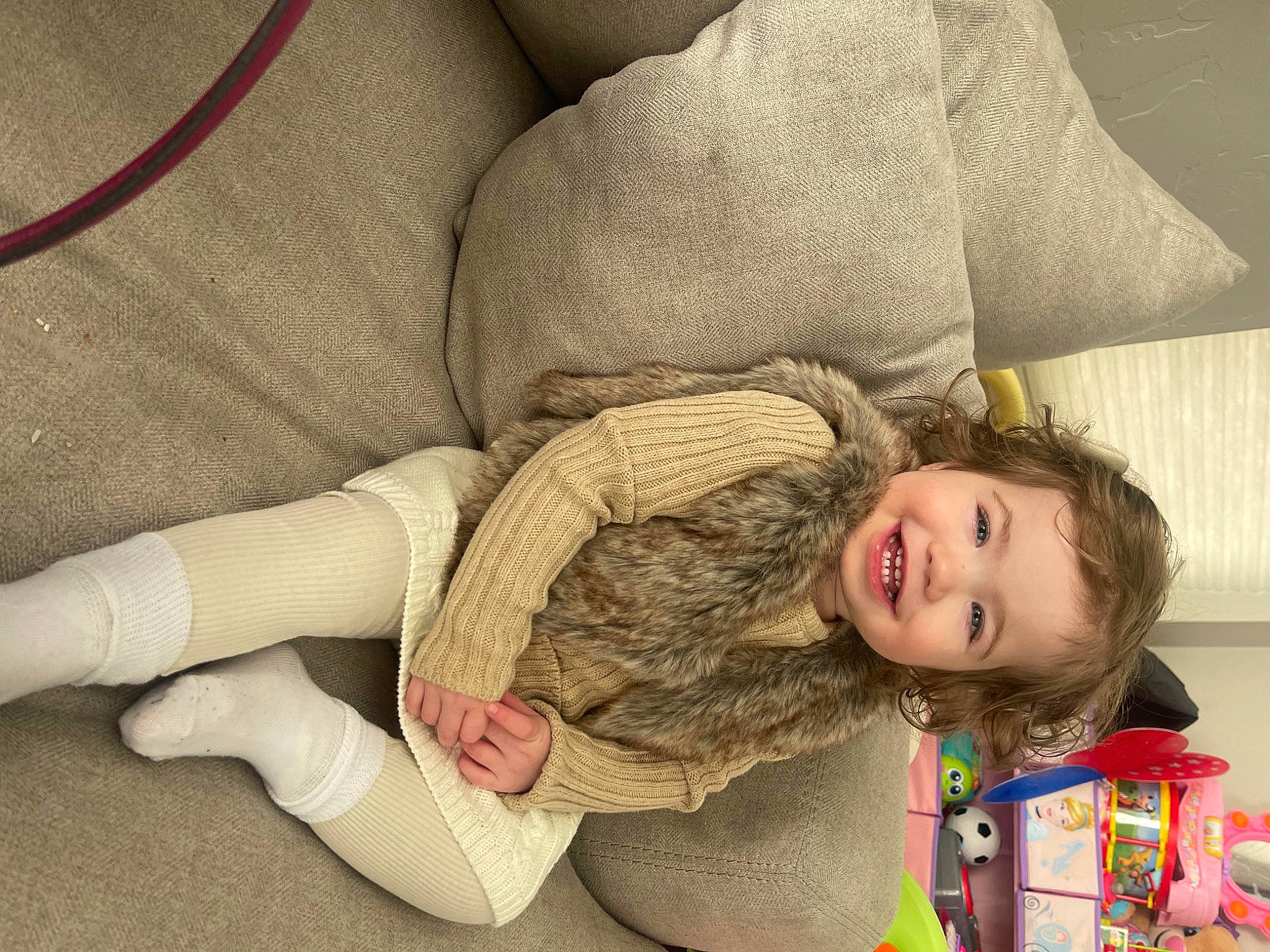 Vera is registered to the contest to win money with this photo: baby_toddler_clothing, child, comfort, flooring, happy, human_body, human_leg, joy, knee, linens, pattern, person, room, sitting, skin, sleeve, smile, textile, thigh, toddler