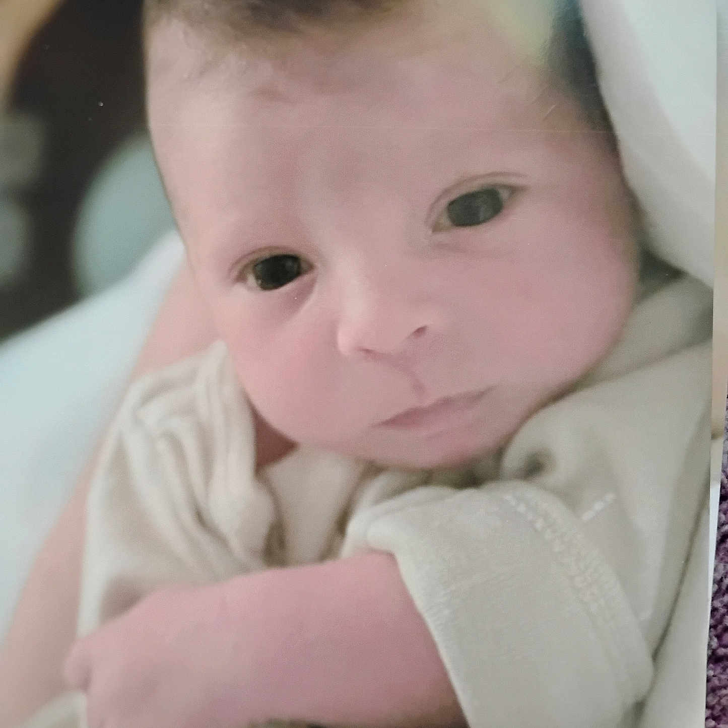 Abel is registered to the contest to win money with this photo: baby, blanket, closeup, clothing, cute, eyes, face, hand, indoors, infant, newborn, newborn_baby, person, portrait, skin, sleepwear, soft, swaddled, toddler, young