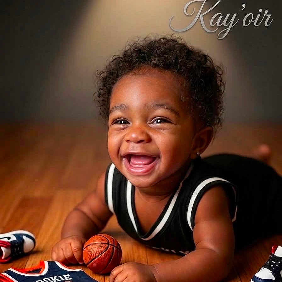 Kayoir joined the competition — help win amazing prizes! baby, child, smiling, laughing, portrait, basketball, sports, jersey, rookie, sneakers, indoor, wood_floor, curly_hair, happy, sitting, crawling, infant, black_clothing, basketball_theme, text_overlay