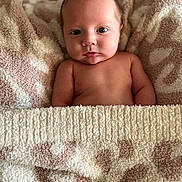 Karter is registered to the contest to win money with this photo: baby, infant, blanket, soft_texture, patterned_blanket, naked_torso, skin, face, eyes, expression, newborn, cute, cozy, lying_down, indoors, child, portrait, warm, comfort, resting