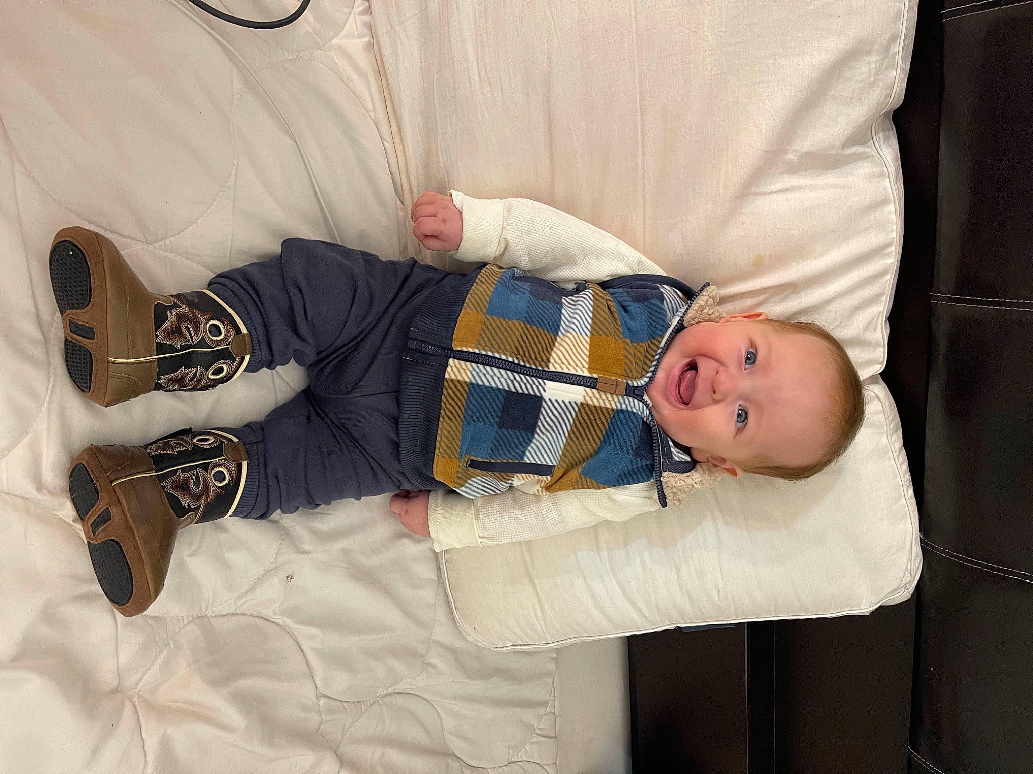 Gael is registered to the contest to win money with this photo: baby, baby_products, baby_toddler_clothing, collar, comfort, couch, dress_shirt, eye, hand, leg, linens, outerwear, pattern, person, product, room, sitting, sleeve, textile, toddler