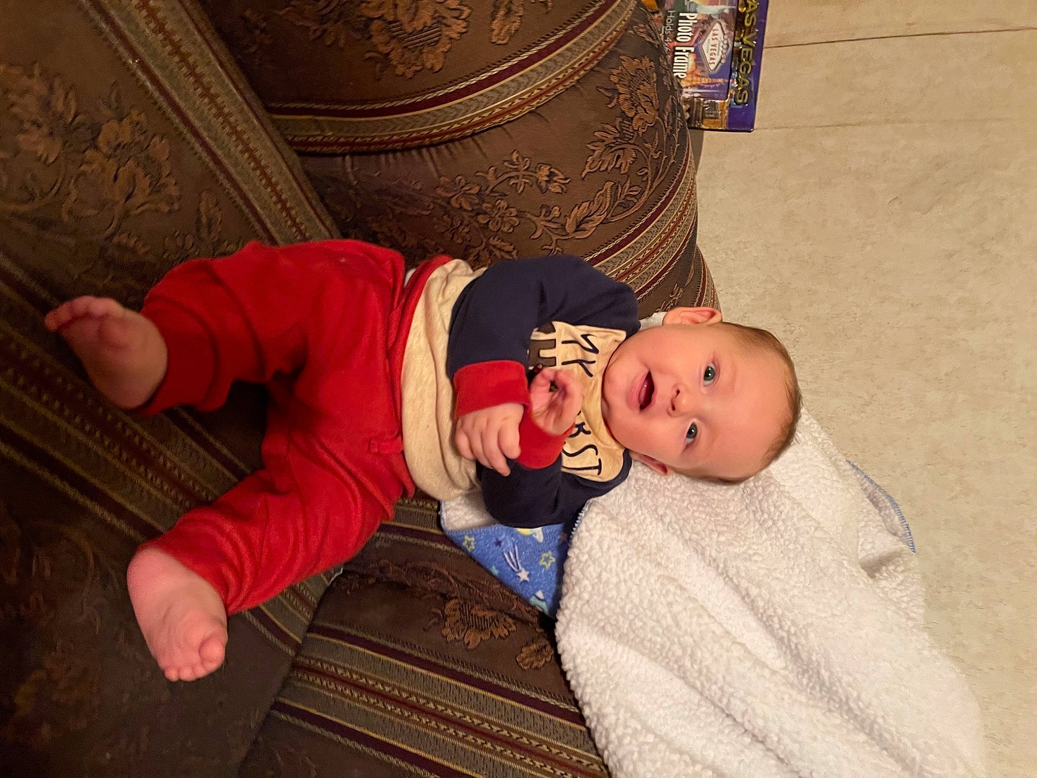 Gael is registered to the contest to win money with this photo: baby, baby_products, baby_toddler_clothing, cheek, child, comfort, finger, flooring, fun, hat, human_body, linens, person, plant, room, sitting, sleeve, toddler, tree, wood