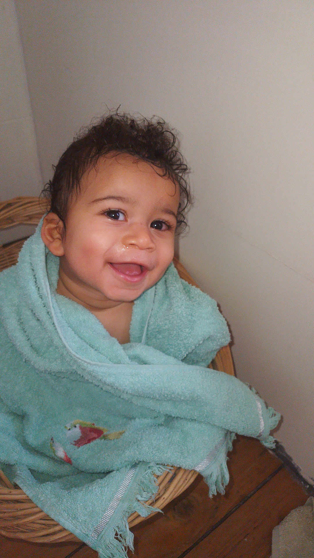 Thomas a rejoint le concours — aidez-le/la à gagner de superbes lots ! baby, child, smiling, towel, basket, curly_hair, indoors, happy, face, person, sitting, wooden_floor, wrapped, cute, infant, portrait, warm, skin, young, expression