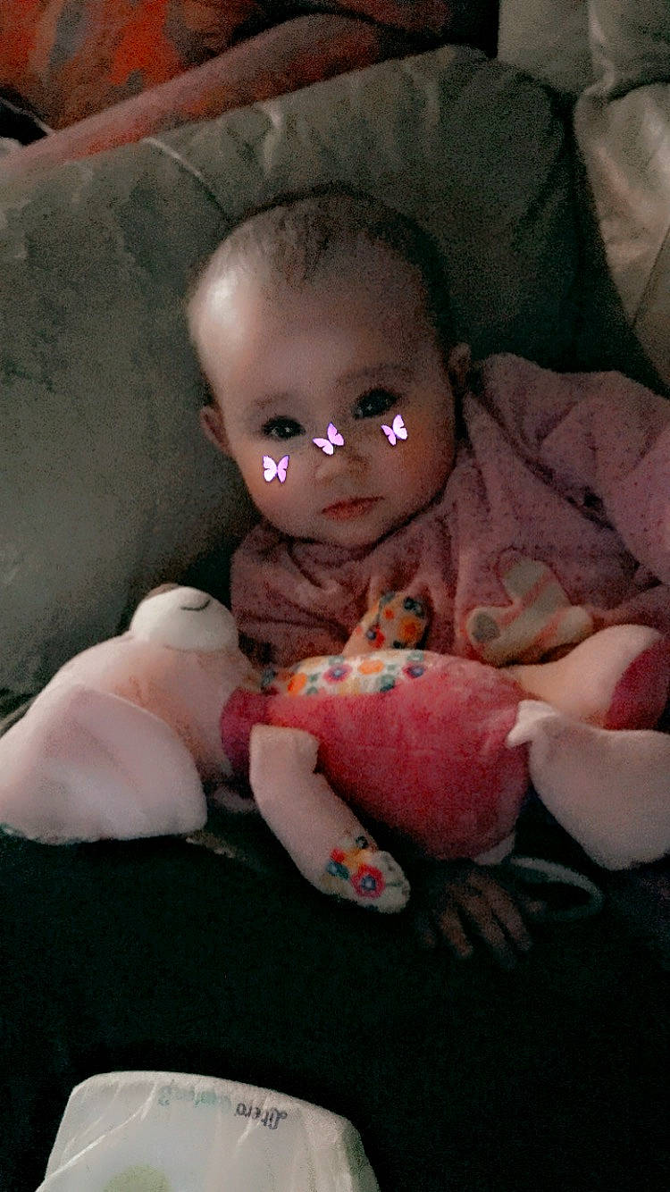 Eliana a rejoint le concours — aidez-le/la à gagner de superbes lots ! baby, baby_toddler_clothing, bed, cheek, comfort, doll, eye, gesture, human_body, linens, lip, mouth, nose, person, pink, skin, stuffed_toy, textile, thumb, toddler