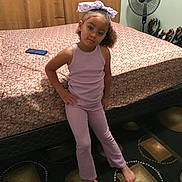 Zaniyah joined the competition — help win amazing prizes! child, girl, purple_outfit, bow, bed, phone, fan, carpet, barefoot, posing, indoor, curtains, furniture, patterned_carpet, smiling, person, home, casual, standing, portrait