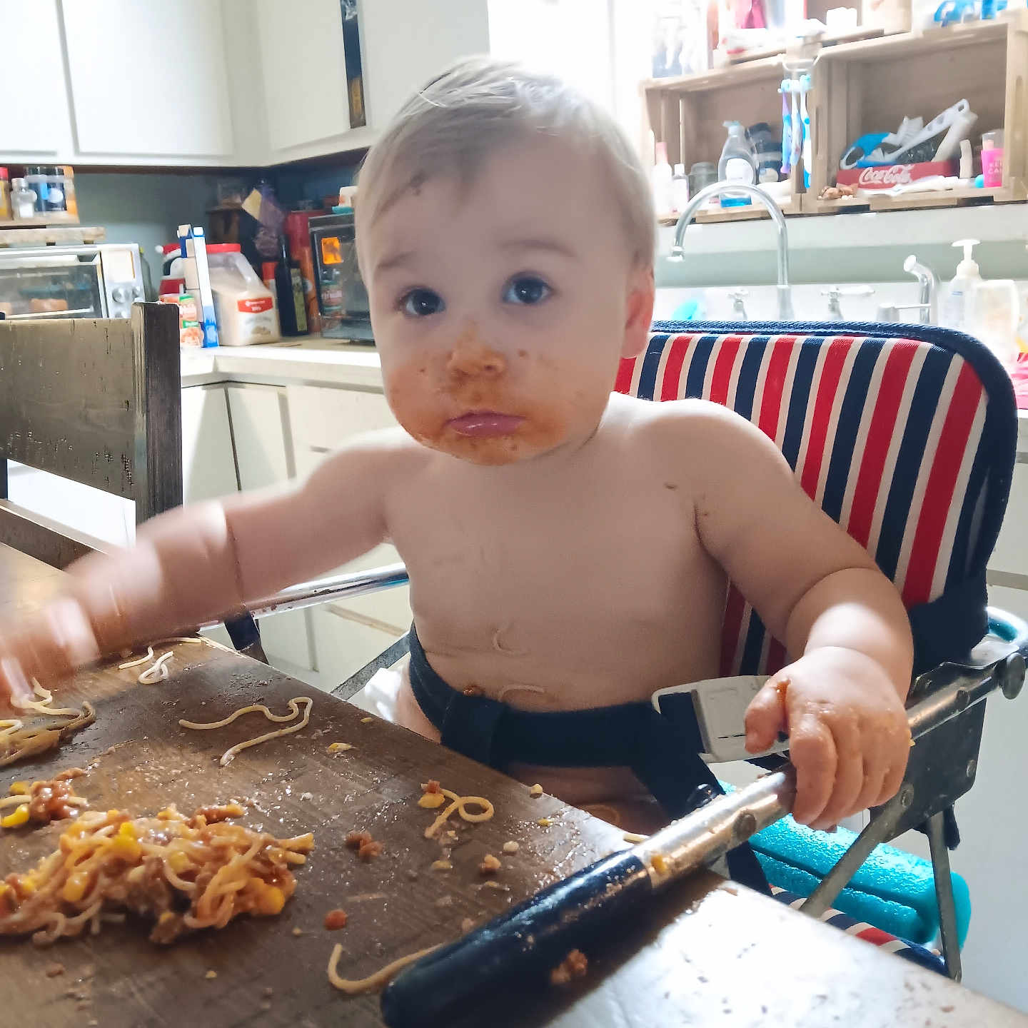 Logan is registered to the contest to win money with this photo: baby, blade, bodypart, cutlery, dagger, eating, face, finger, food, furniture, hand, head, kitchenutensil, knife, person, photography, plywood, portrait, weapon, wood