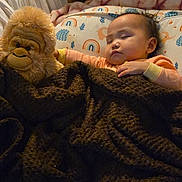 Shameka joined the competition — help win amazing prizes! baby, sleeping, blanket, stuffed_animal, gorilla_toy, pillow, rainbow_pattern, bedtime, cozy, child, indoor, soft_lighting, cute, resting, toddler, plush_toy, comfort, infant, peaceful, sleep