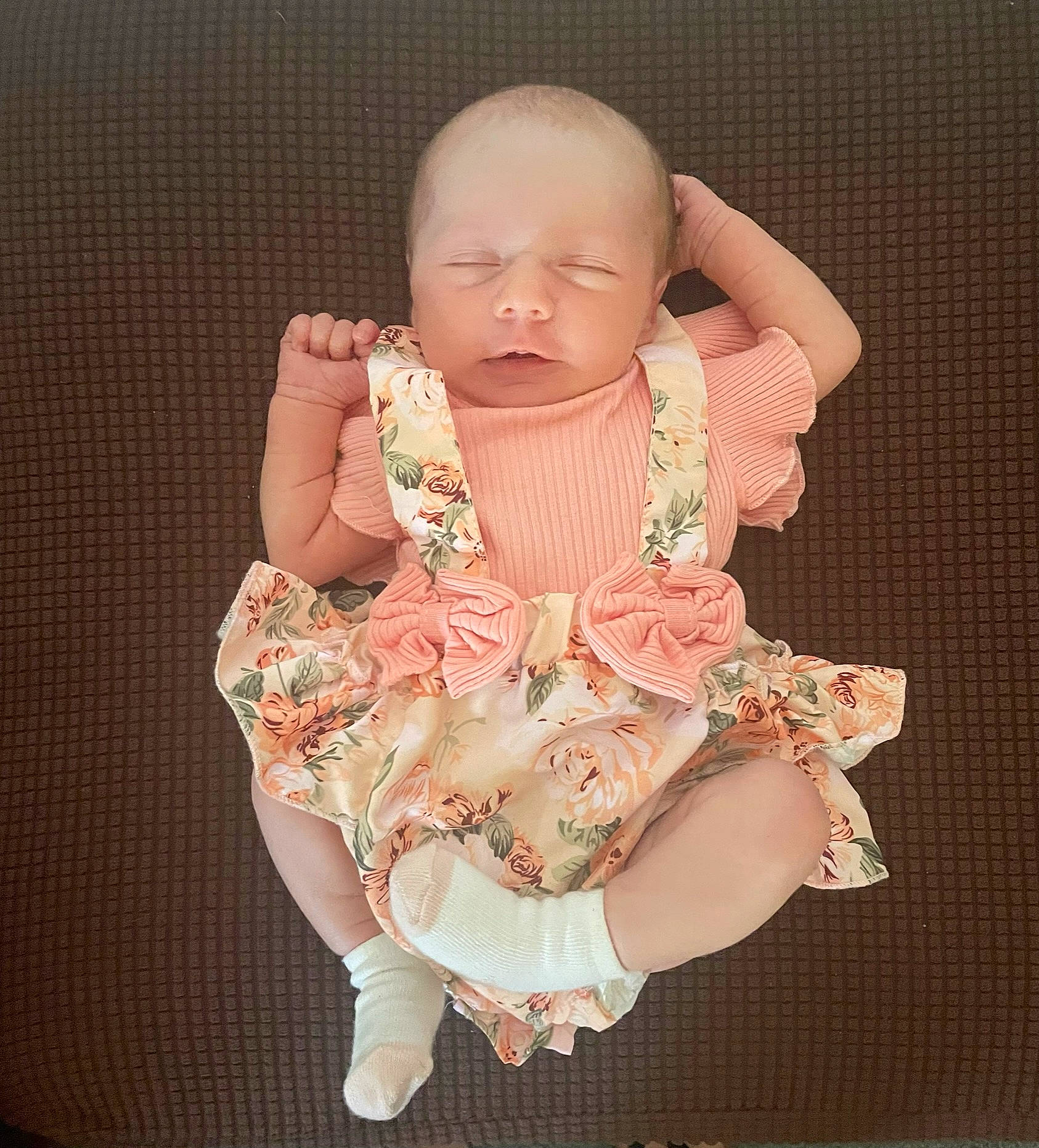 Sydney is registered to the contest to win money with this photo: arm, baby, baby_products, baby_toddler_clothing, cheek, dress, embellishment, gesture, head, human_body, nail, neck, pattern, peach, person, pink, sitting, sleeve, thumb, toddler