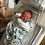 Aylin is registered to the contest to win money with this photo: newborn, baby, infant, sleeping, blanket, dinosaur_print, hospital, bassinet, pacifier, swaddled, face, head, cute, resting, indoors, bed, white_clothing, crib, soft_lighting, peaceful