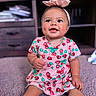 baby, child, infant, cute, smiling, pink_dress, strawberry_pattern, headband, bow, sitting, carpet, indoors, furniture, cabinet, happy, portrait, adorable, chubby_cheeks, bright_eyes, person