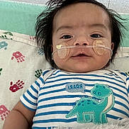 Isaac joined the competition — help win amazing prizes! baby, infant, child, nasal_tube, oxygen_tube, medical, hospital, onesie, striped_clothing, dinosaur_patch, blanket, handprint_pattern, face, hair, lying_down, cute, calm, closeup, indoors, healthcare