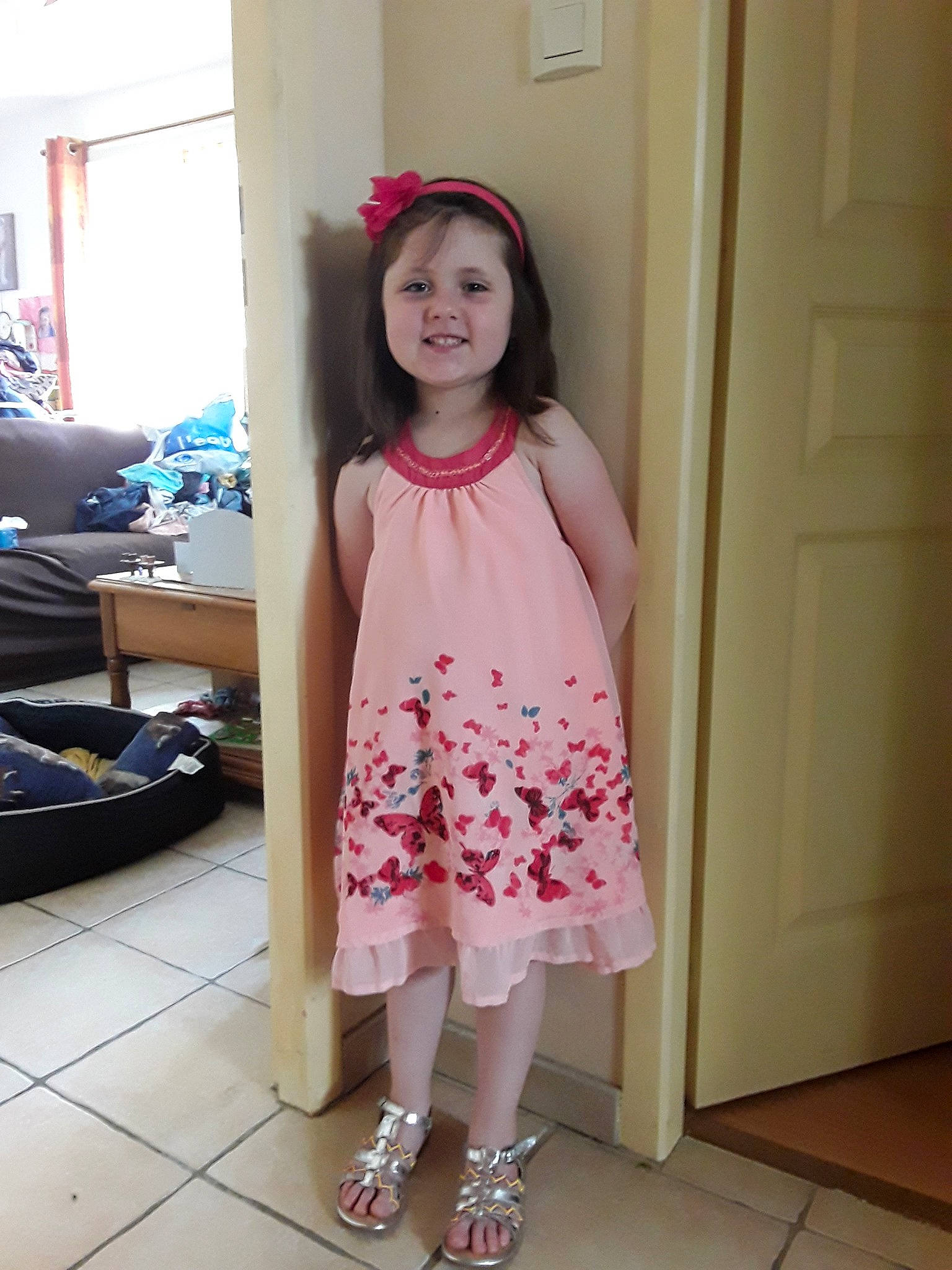 Aëla participe au concours pour gagner de l'argent avec cette photo : baby_toddler_clothing, bag, bangs, door, fashion_design, happy, human_leg, joy, knee, leg, luggage_and_bags, magenta, neck, pattern, person, pink, shoulder, sleeve, smile, thigh