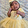 baby, infant, child, portrait, lying_down, yellow_dress, headband, bow, tulle, dress, patterned_blanket, polka_dots, face, hands, indoor, close_up, cute, fashion, newborn, photography