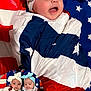 baby, infant, child, headwrap, bow, american_flag, blanket, swaddled, patriotic, stars, stripes, red, white, blue, portrait, cute, smiling, face, person, indoor