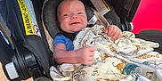 Kegan joined the competition — help win amazing prizes! baby, infant, car_seat, blanket, smile, happy, child, indoor, clothing, fabric, seat, safety, cute, person, head, comfort, pattern, animal_print, pacifier, wood_floor