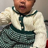 Demariona joined the competition — help win amazing prizes! baby, bows, child, cozy, cream, curious, cute, eyes, face, green, hand, indoor, infant, knitted_clothing, person, portrait, sitting, socks, soft_lighting, young