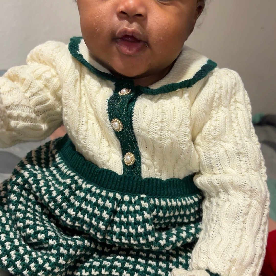 Demariona joined the competition — help win amazing prizes! baby, bows, child, cozy, cream, curious, cute, eyes, face, green, hand, indoor, infant, knitted_clothing, person, portrait, sitting, socks, soft_lighting, young