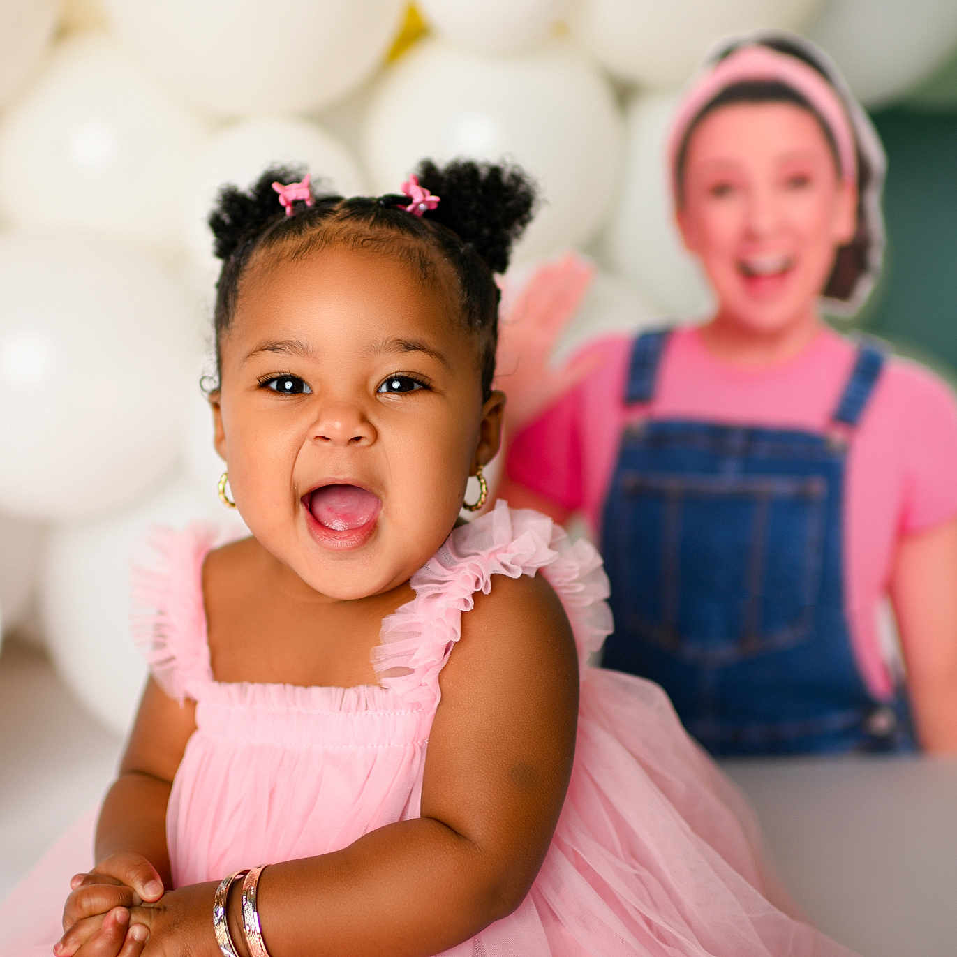 Lannie joined the competition — help win amazing prizes! accessories, baby, balloons, bracelets, celebration, child, clothing, cute, earrings, fun, hair_buns, happy, indoor, joy, person, pink_dress, portrait, smiling, toddler, yellow_background