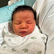 Dallas joined the competition — help win amazing prizes! newborn, baby, swaddle, sleeping, infant, face, head, blanket, bed, comfort, rest, peaceful, soft, person, human, skin, hair, indoors, closeup, portrait