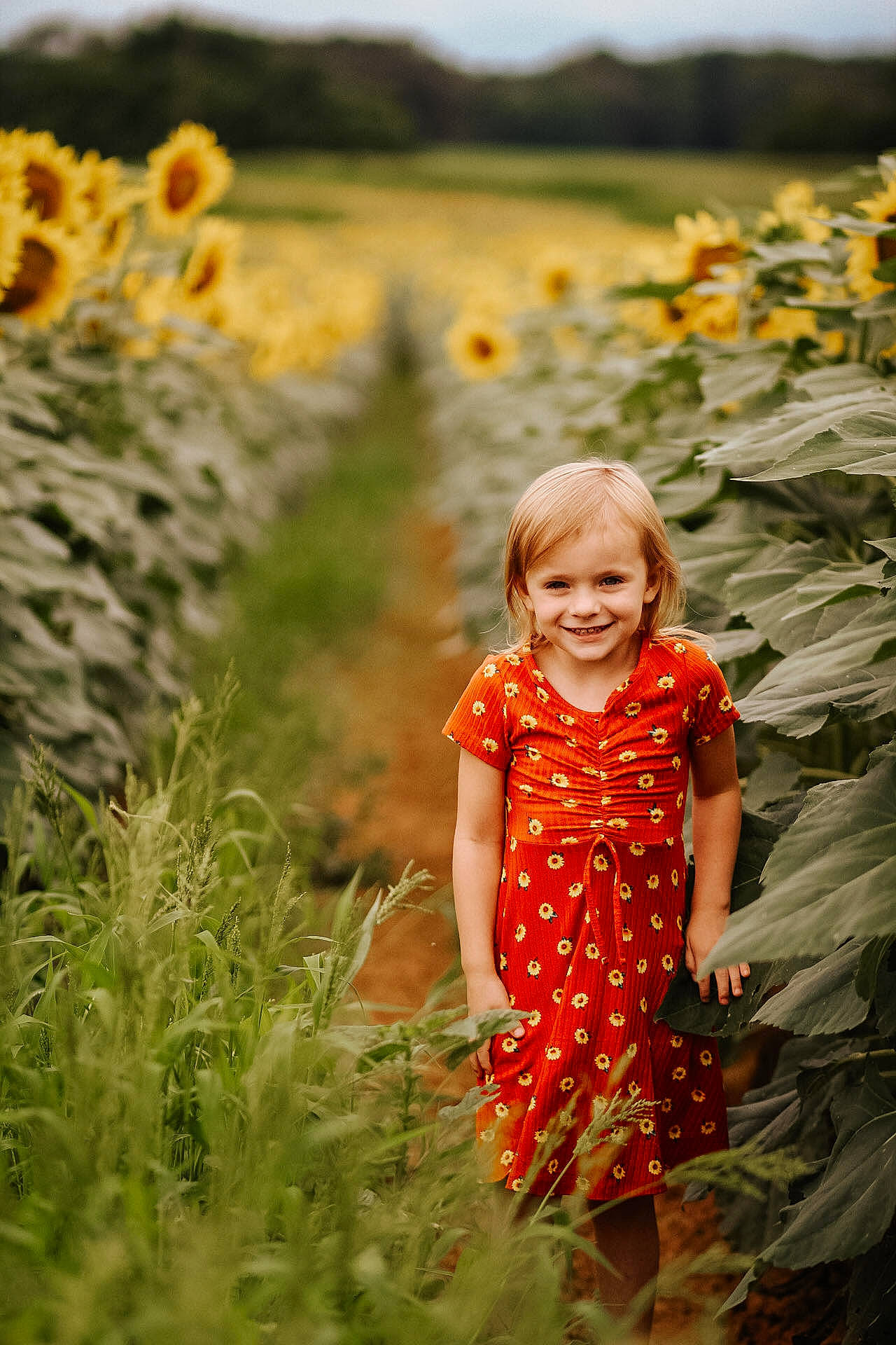 Hazel is registered to the contest to win money with this photo: botany, clothing, dress, flower, grass, grassland, happy, head, joy, landscape, leaf, meadow, natural_environment, natural_landscape, people_in_nature, person, plant, sky, smile, summer