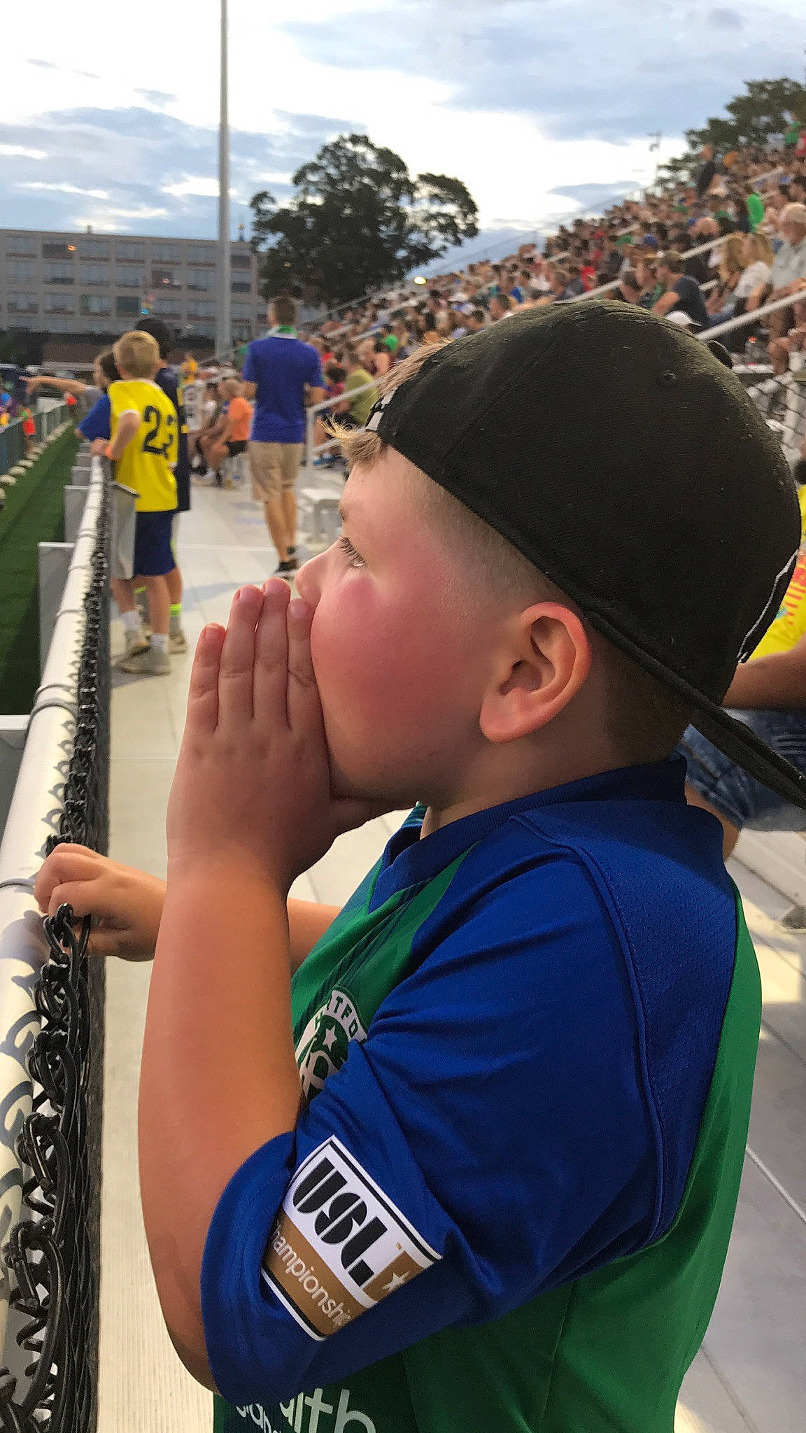 Javien is registered to the contest to win money with this photo: baseball_cap, cap, cloud, competition_event, elbow, electric_blue, fun, gesture, grass, hat, leisure, person, player, recreation, shorts, sky, stadium, summer, t_shirt, toddler