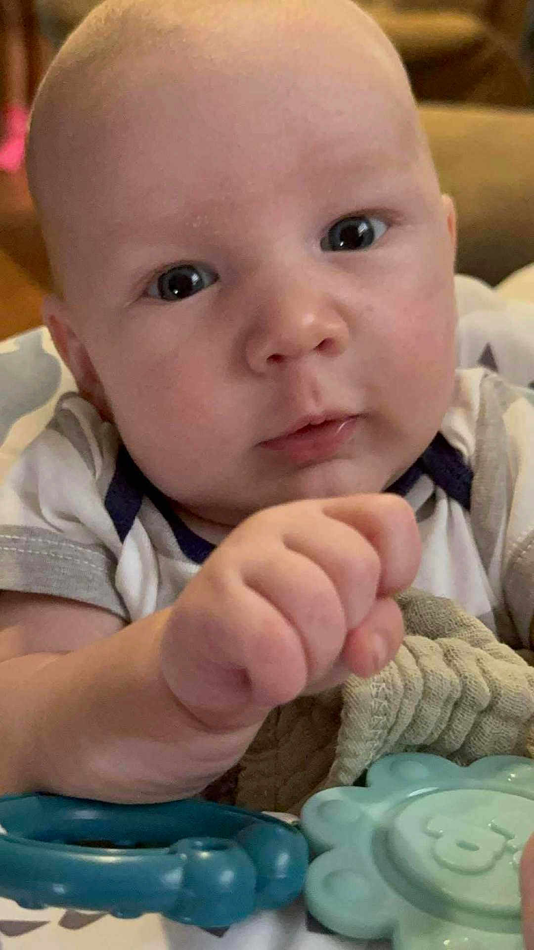 Blaine joined the competition — help win amazing prizes! baby, infant, face, hand, teething_toy, blanket, closeup, curious, indoors, child, cute, skin, person, clothing, young, portrait, expression, soft, comfort, toy