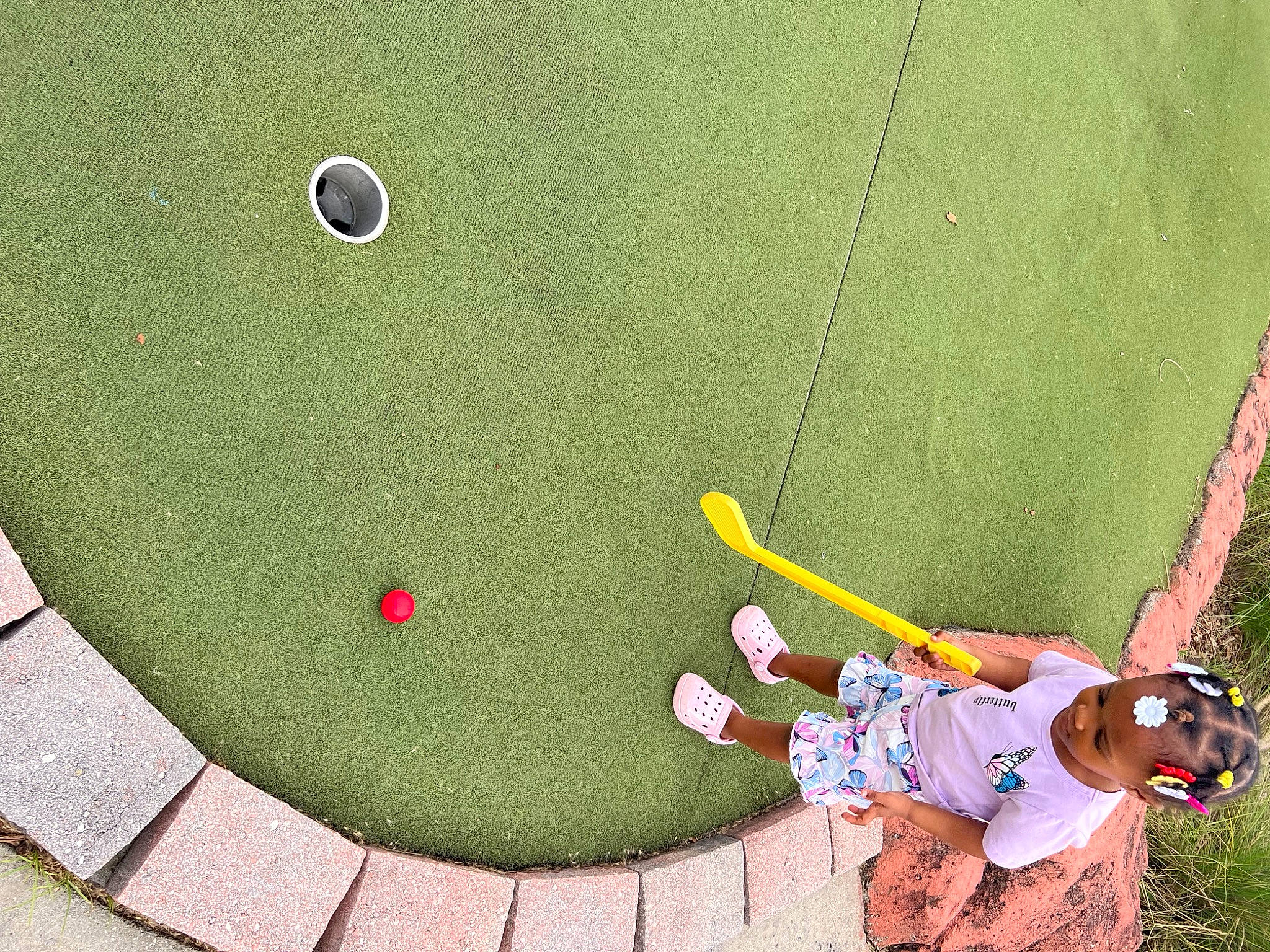 Serenity is registered to the contest to win money with this photo: adventure, circle, concrete, flooring, fun, grass, landscape, leisure, organism, person, plant, play, player, recreation, road_surface, rope, shrub, sneakers, sport_climbing, sports