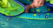 Owen is registered to the contest to win money with this photo: baby, pool, water, inflatable, float, child, swimming, blue, green, skin, relaxing, summer, toy, cute, infant, floating, swimwear, leisure, baby_toy, resting