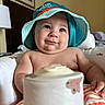 Owen joined the competition — help win amazing prizes! baby, child, hat, smile, indoor, bottle, cushion, seat, portrait, face, skin, headwear, orange_stripes, furniture, lamp, picture_frame, happy, young, cute, chubby