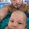 Owen is registered to the contest to win money with this photo: baby, man, pool, water, tattoos, face, portrait, swimming, child, adult, closeup, indoor, relaxation, fun, family, leisure, skin, headwear, tattooed_arm, floating_device