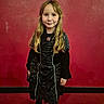 child, girl, costume, black_clothing, long_hair, blonde_hair, smile, standing, boots, indoor, red_wall, portrait, fashion, holiday, cute, person, happy, event, celebration, posing