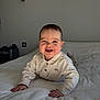 baby, smiling, infant, bed, white_bedspread, clothing, indoor, cute, happy, child, portrait, pajamas, hands, face, head, light, cozy, home, sleepwear, crawling