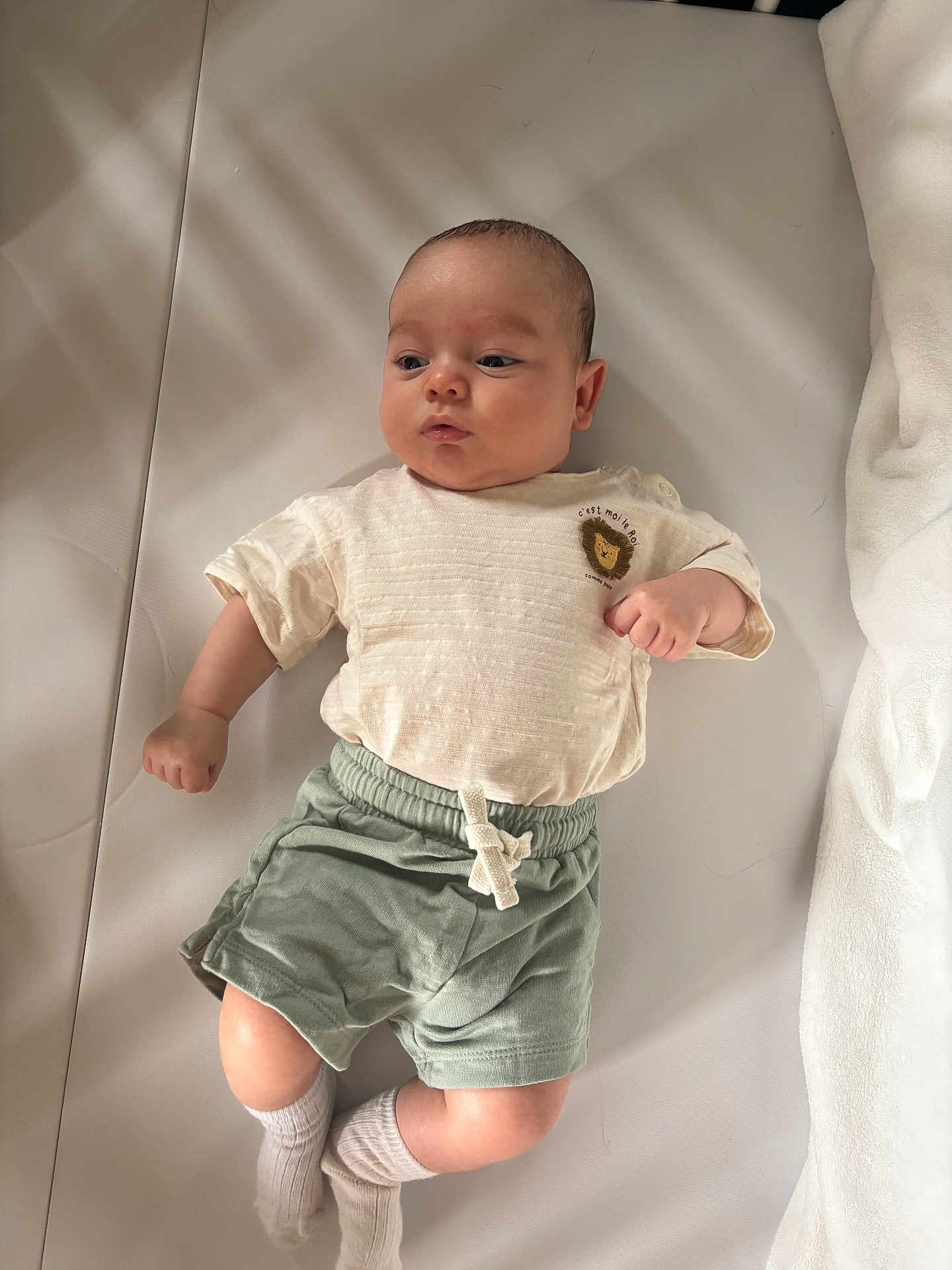 Ethan a rejoint le concours — aidez-le/la à gagner de superbes lots ! baby, infant, child, lying_down, shirt, shorts, socks, face, head, skin, expression, soft_lighting, indoor, blanket, fabric, comfort, cute, calm, young, portrait