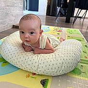 Ethan participe au concours pour gagner de l'argent avec cette photo : baby, infant, pillow, floor, play_mat, indoor, wood_floor, curious, face, head, person, clothing, furniture, modern, room, chair, table, carpet, cute, child