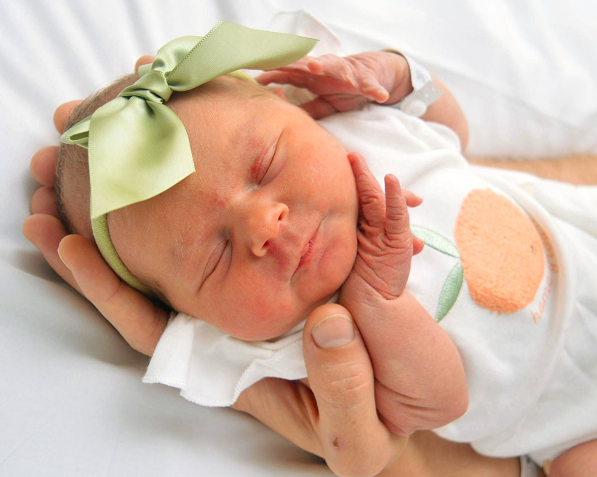 Clementine is registered to the contest to win money with this photo: baby, baby_products, baby_sleeping, baby_toddler_clothing, child, comfort, costume_hat, event, fashion_accessory, finger, gesture, hand, headwear, human_body, linens, peach, person, product, skin, thumb