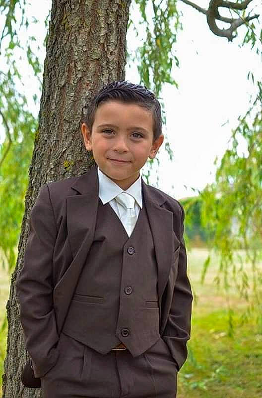 Hakim participe au concours pour gagner de l'argent avec cette photo : adaptation, child, child_model, formal_wear, jacket, joy, outerwear, person, smile, suit, tree, tuxedo