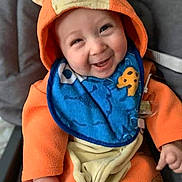 Elijah Butler joined the competition — help win amazing prizes! baby, child, smiling, happy, portrait, orange_outfit, animal_hood, hooded_clothing, bib, car_seat, seated, infant, face, hands, indoor, close_up, colorful, cute, photography, joy